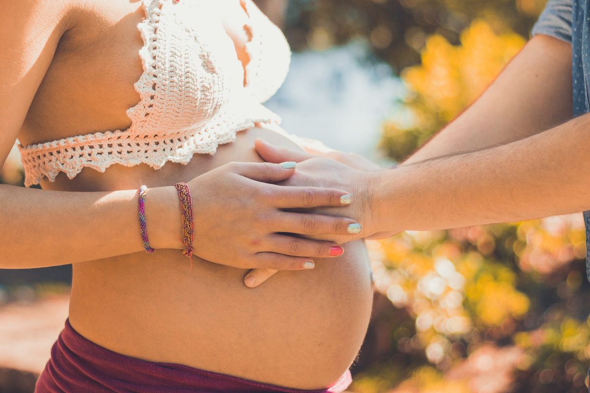 Parent Hands Touching Pregnant Woman Belly